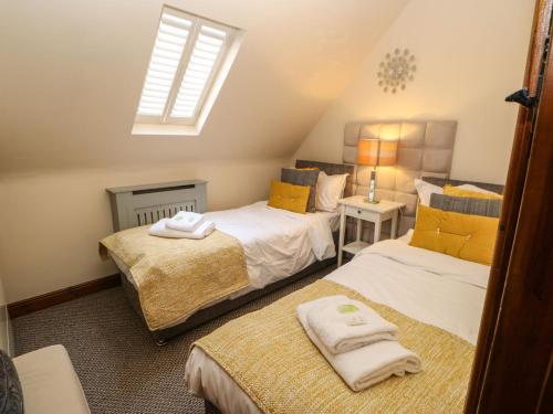 a bedroom with two beds and a window at Dere Cottage in Richmond