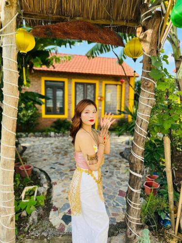a woman standing next to a palm tree at Ninh Binh Royal Homestay in Ninh Binh