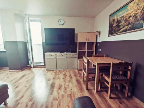 a living room with a table and a television at Apartment for a short rent in KaunasButas trumpalaikei nuomai Kaune in Kaunas
