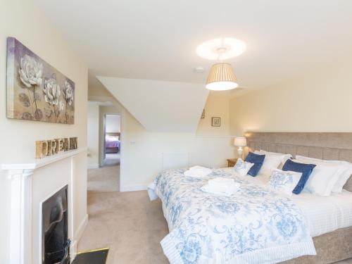 a bedroom with a bed and a fireplace at Chauffeur's Cottage with Hot Tub in Cray