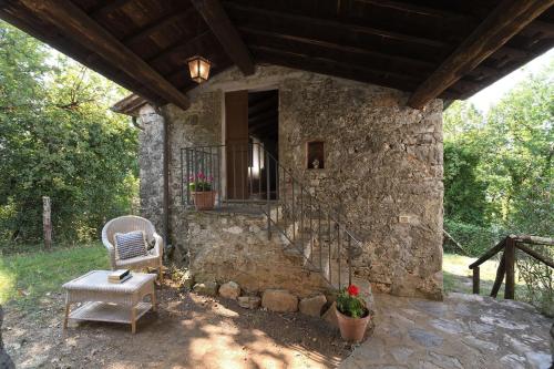 a stone house with a chair and a window at Casa Manu in Coreglia Antelminelli