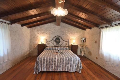 a bedroom with a bed and a chandelier at Casa Manu in Coreglia Antelminelli
