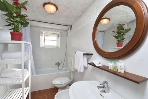 a bathroom with a sink and a mirror and a toilet at Casa Manu in Coreglia Antelminelli