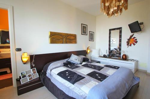 ein Schlafzimmer mit einem großen Bett und einem Spiegel in der Unterkunft Vista Mare in Montignoso