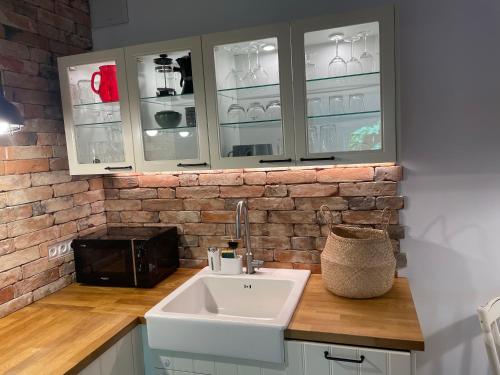 een keuken met een wastafel en een bakstenen muur bij Apartament z ogrodem in Starogard Gdański