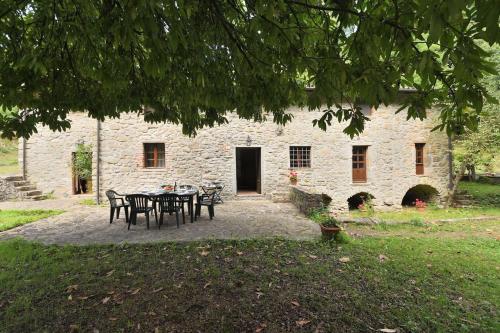 a table and chairs in front of a stone building at Il Vecchio Mulino in Coreglia Antelminelli