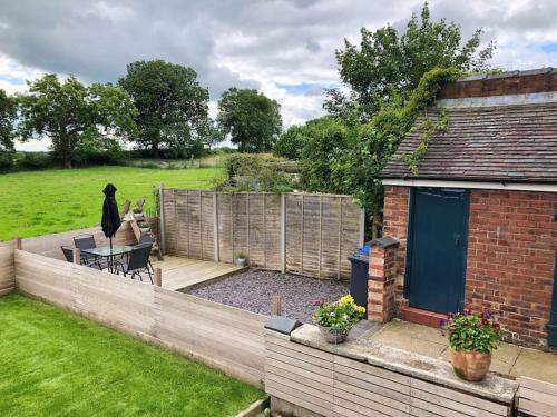 a woman standing on a deck in a backyard at Quaint house in a beautiful rural setting in Froghall