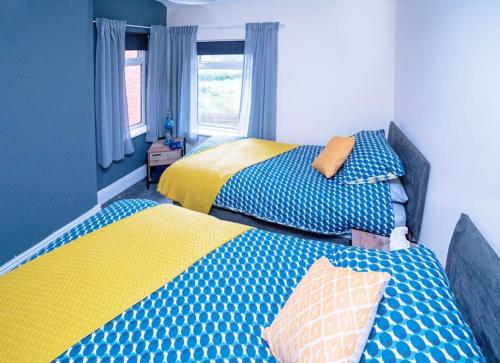 two beds sitting next to each other in a bedroom at Quaint house in a beautiful rural setting in Froghall