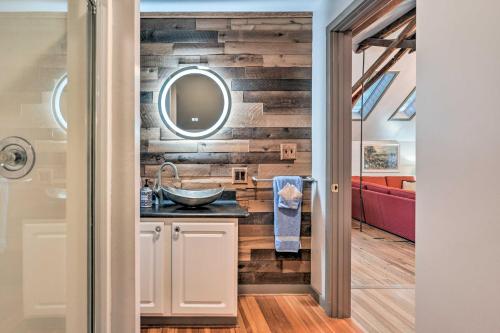 a bathroom with a wooden wall with a sink and a mirror at Pet-Friendly Loft Vacation Rental with Fire Pit! in Bemus Point