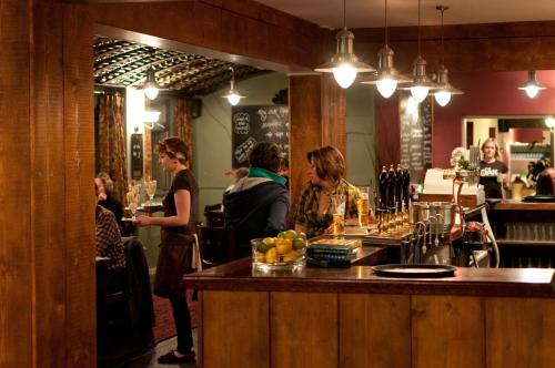 a group of people sitting at a bar in a restaurant at Oak Inn in Upton Snodsbury