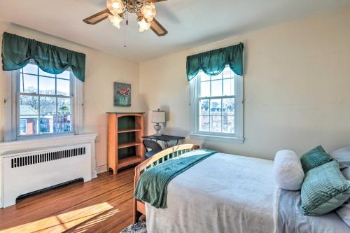 a bedroom with a bed and two windows at Yeadon Townhome with Porch, 7 Mi to Center City in Drexel Hill