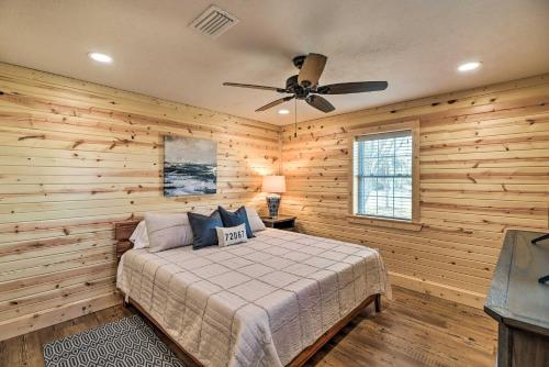 een slaapkamer met houten wanden en een bed met een plafondventilator bij Greers Ferry Home on 40 Acres quarter Mi to Lake! in Fairfield Bay