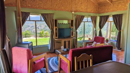 a living room with a couch and a tv at Cabaña el Coirón in Cochrane