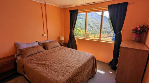a bedroom with a bed and a window at Cabaña el Coirón in Cochrane