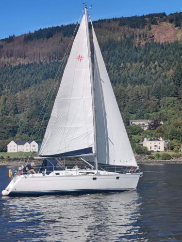 a white sailboat on the water in a lake at Douglas Park Guest House in Dunoon