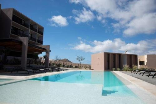 a large swimming pool in front of a building at Miro Masia in Cabo San Lucas