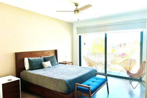 a bedroom with a bed and chairs and a window at Miro Masia in Cabo San Lucas