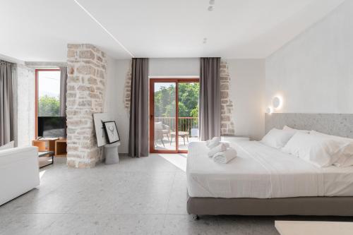 - une chambre blanche avec un grand lit et un balcon dans l'établissement Kampus Luxury Villas, à Tríkala