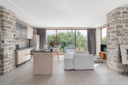 cocina con electrodomésticos blancos y pared de ladrillo en Kampus Luxury Villas, en Tríkala