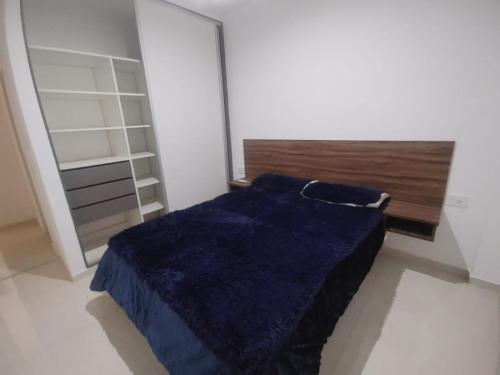 Un dormitorio con una manta azul en una cama en Punto de encuentro 2 en Corrientes