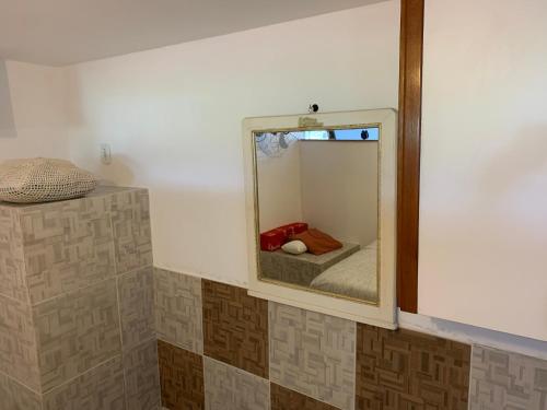 baño con espejo y cama en una habitación en Casa de hospedagem no Mirante de Piratininga en Niterói