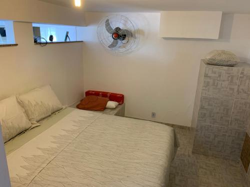 a small bedroom with a bed and a fan at Casa de hospedagem no Mirante de Piratininga in Niterói