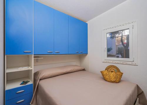 a small bedroom with blue cabinets and a bed at Villaggio Leucosia in Santa Maria di Castellabate