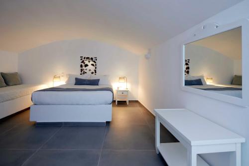 a bedroom with a bed and a table and a mirror at Marizan Caves & Villas in Oia