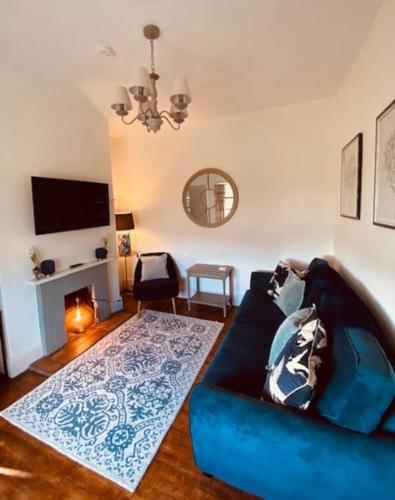 a living room with a blue couch and a fireplace at Cosy Bungalow with a view in Lincoln