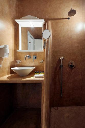 a bathroom with a sink and a mirror at Marizan Caves & Villas in Oia