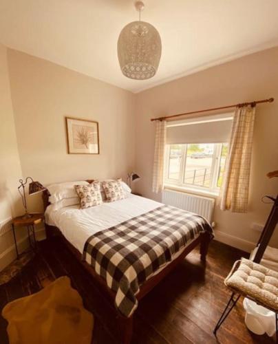 1 dormitorio con 1 cama con manta a cuadros en Cosy Bungalow with a view en Lincoln