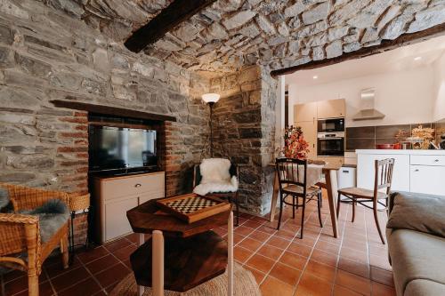 una sala de estar con una pared de piedra en Tiny stone, en Maredret