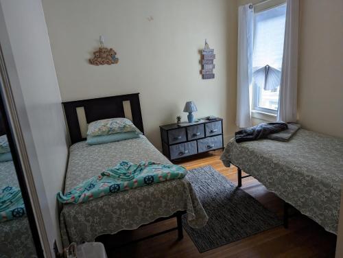 een slaapkamer met 2 bedden, een dressoir en een raam bij Cozy corner in Rochester