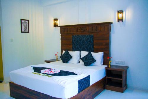 a bedroom with a large bed with a wooden headboard at Manike Lodge Habarana in Habarana