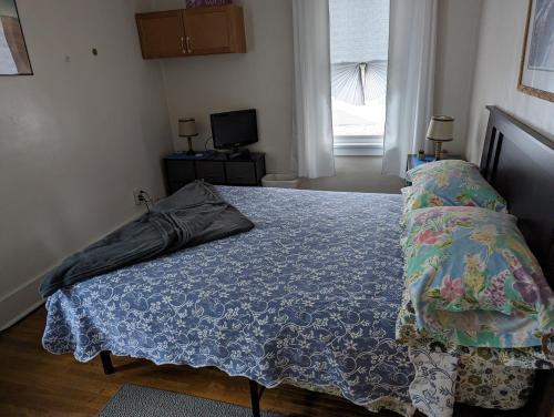 een slaapkamer met een bed met een blauw dekbed bij Cozy corner in Rochester