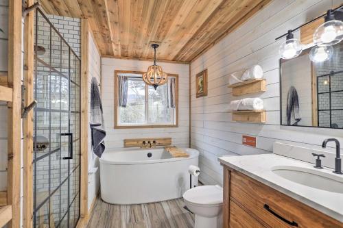 a bathroom with a tub and a toilet and a sink at Adirondack Oasis Private Lake, Sauna, and Fire Pit in Chestertown