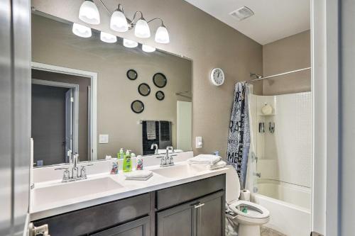 een badkamer met een wastafel, een toilet en een spiegel bij Phoenix Area Vacation Home with Private Pool! in Buckeye