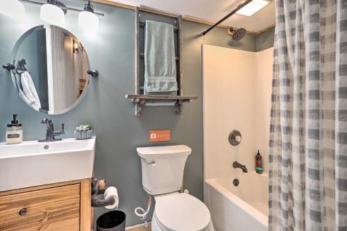a bathroom with a toilet and a sink and a mirror at Adirondack Oasis Private Lake, Sauna, and Fire Pit in Chestertown