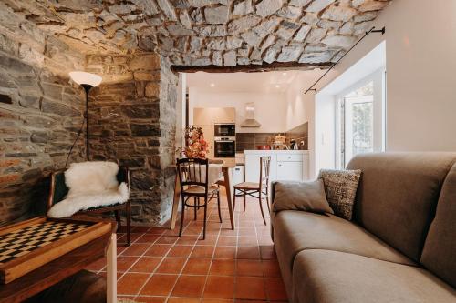 ein Wohnzimmer mit einem Sofa und einem Esszimmer in der Unterkunft Tiny stone in Maredret