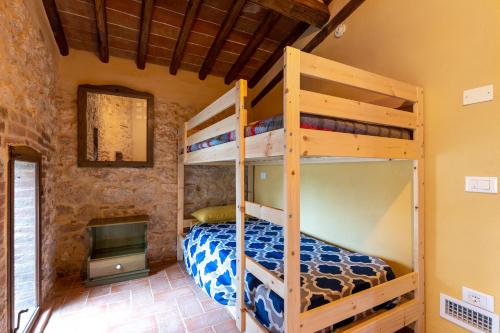 a bedroom with bunk beds in a room with a fireplace at Casa di Campagna in Colle Val D'Elsa