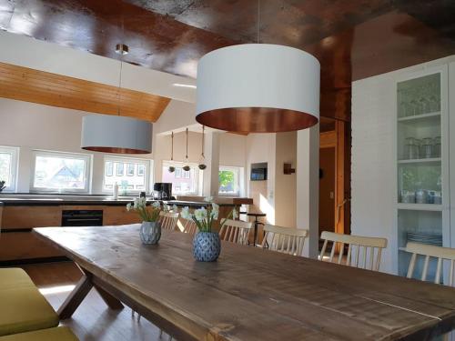 a kitchen with a wooden table with two vases on it at 16 Personen Harzhaus für Gruppen in Clausthal-Zellerfeld in Clausthal-Zellerfeld