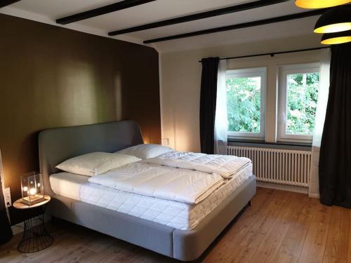 a bedroom with a white bed and a window at 16 Personen Harzhaus für Gruppen in Clausthal-Zellerfeld in Clausthal-Zellerfeld