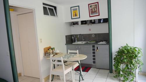 - une petite cuisine avec une petite table et des chaises dans l'établissement Gite aux Minimes - Au jardin des alouettes, à Toulouse