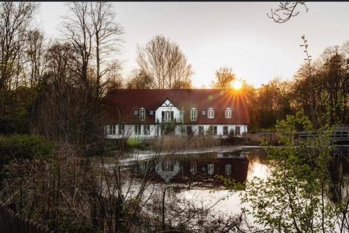 ein großes Haus inmitten eines Wasserkörpers in der Unterkunft Fürst Bismarck Mühle in Aumühle