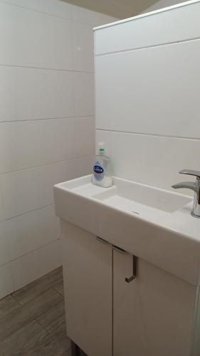La salle de bains est pourvue d'un lavabo blanc et d'un miroir. dans l'établissement Charming 1-Bed Cottage on the outskirts of Haworth, à Keighley