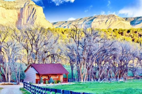 a red barn in a field with mountains in the background at Arrowhead Country Inn and Cabins in Mount Carmel