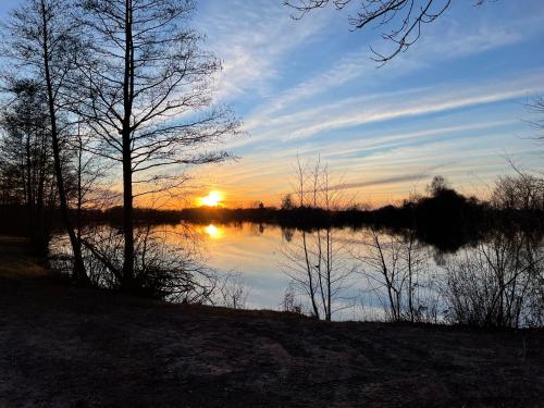 un tramonto su un corpo di acqua con alberi di Haus Dragl DZ EZ a Friedberg