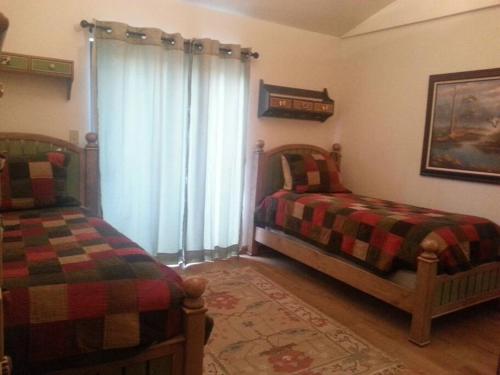 a bedroom with two beds and a window at Cozy Flagstaff Home in Cool Pines - Country Club in Flagstaff