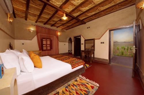 Ecolodge l'île de Ouarzazate في ورززات: غرفة نوم بسرير ونافذة كبيرة