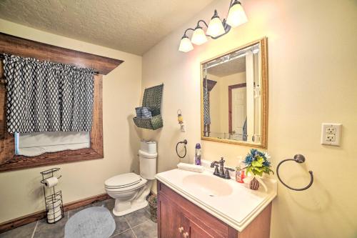 a bathroom with a sink and a toilet and a mirror at Charming McKenzie Farmhouse with Fire Pit! in McKenzie